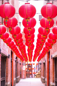 美丽的圆形红灯笼挂在古老的传统街道上，中国农历新年的概念，特写。这个词的意思是祝福。