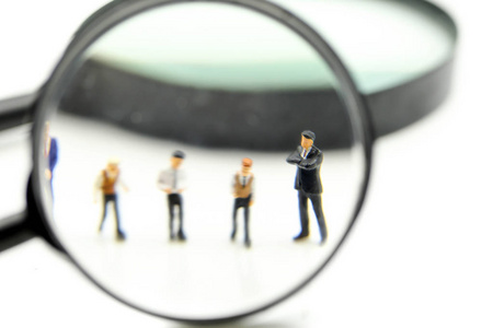 Miniature people  Successful businessman with magnifying glass 