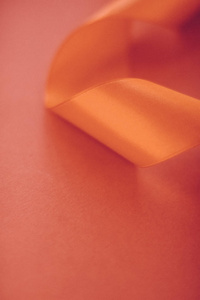 橙色背景上抽象的卷曲丝带，奢华至极