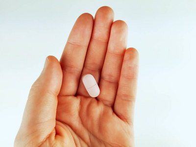 掌心握着一片药片的特写和俯视图,作为适当的治疗剂量,没有药物滥用