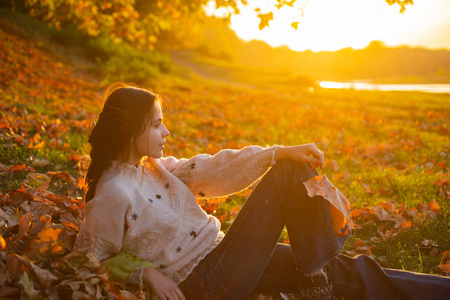 秋天的自然观美丽的秋天傍晚日落时美丽的黑发女人的侧面肖像.