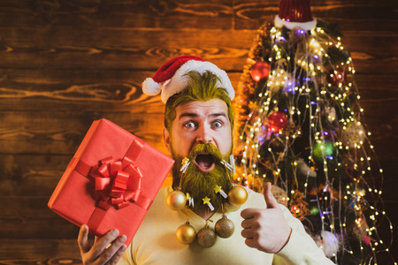 主题圣诞假期和冬季新年。圣诞老人的肖像。冬天的情感。圣诞木背景上摆着白胡子的圣诞老人。
