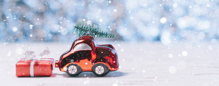 一辆小玩具车的特写镜头在屋顶上放着一棵圣诞树