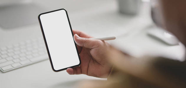 Closeup view of young man holding smartphone in modern  r