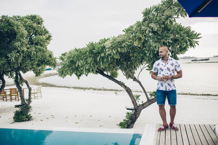 马尔代夫度假胜地的运动帅哥,带着一杯清凉的香肠照片