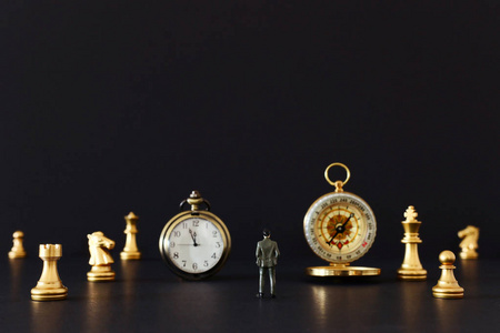 象棋游戏的图像。商人看复古时钟，指南针和棋子，竞争，战略，领导和成功的概念