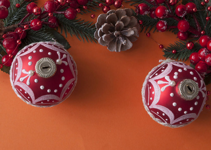 Christmas balls, berries and cones with copyspace on red paper 