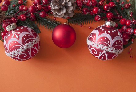 Christmas balls, berries and cones with copyspace on red paper 