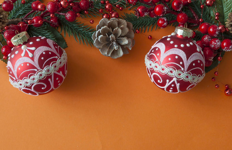 Christmas balls, berries and cones with copyspace on red paper 