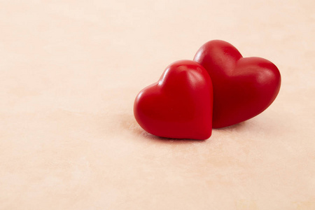 粉红色背景上的两颗红心照片