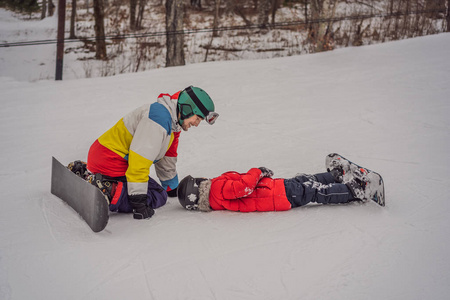 滑雪板教练教男孩滑雪。冬季儿童活动。儿童冬季运动。生活方式