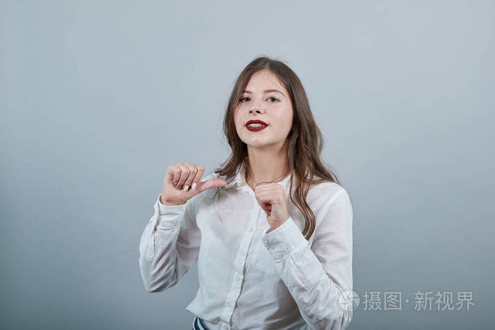 白人黑发女人，用拇指指着自己，看上去很高兴