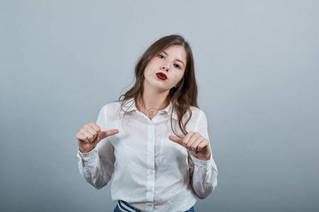 白人黑发女人用拇指指着自己，看上去很失望