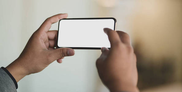 Cropped shot of young businessman using blank screen smartphone 