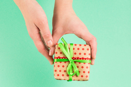 Present in woman hand on a green background. 