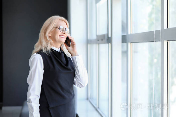 成熟的女商人在办公室打电话