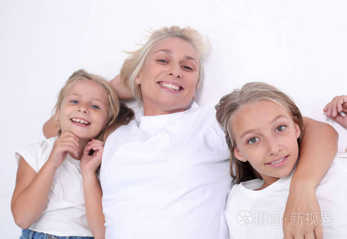 快乐的妈妈和她的两个女儿看着镜头