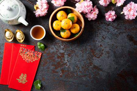 中国的春节装饰波或红包，橙色和金锭或黄金块在黑色石头纹理的背景。汉字福的意思是好运好运财富金钱流动。