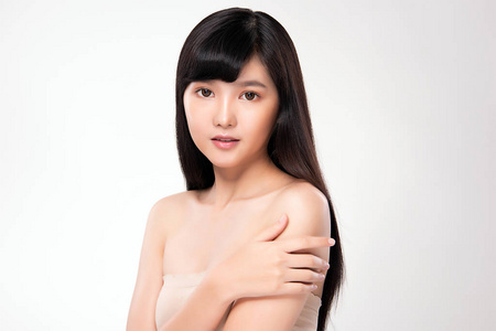 年轻美丽的亚洲女人，皮肤干净清新。面部护理，面部护理，白底，美容化妆品概念