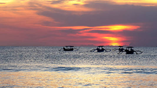巴厘岛库塔海滩渔船的日落照片图片