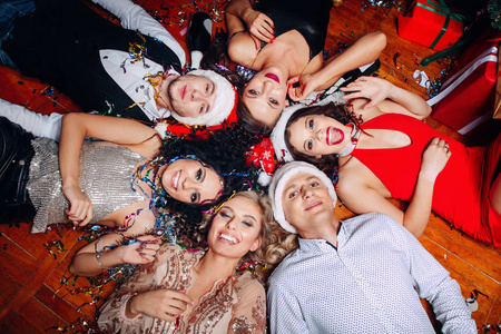 一群朋友在俱乐部里玩得开心，躺在地板上。新年聚会