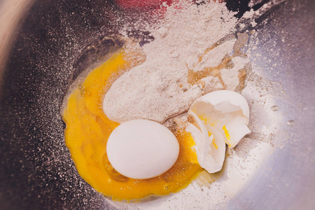 一个碎鸡蛋和面粉放在一个碗里。做松饼。