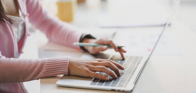 Cropped shot of businesswoman typing on laptop computer while wo