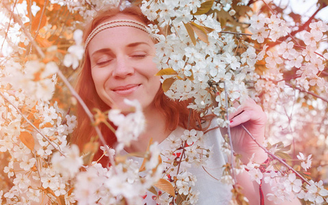 A girl on a walk in a park. Young redhaired girl in the spring 