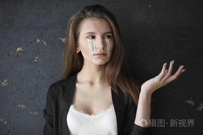 眼含泪水的美丽女孩画着t字的小女孩
