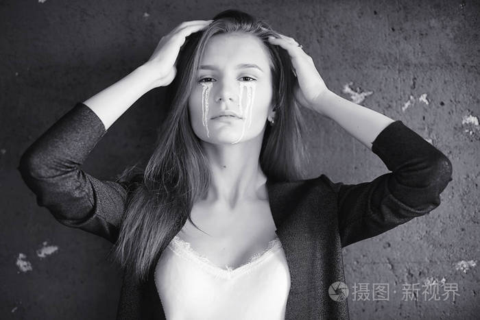 眼含泪水的美丽女孩画着t字的小女孩