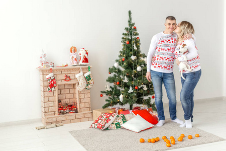 假日概念快乐的男人和女人在家里的圣诞树