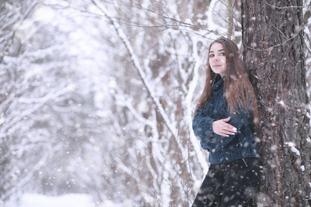 降雪中的冬天公园里的女孩