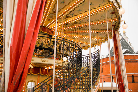 旋转木马marry的天花板环绕着马,铁制的后楼梯以建筑物为背景.