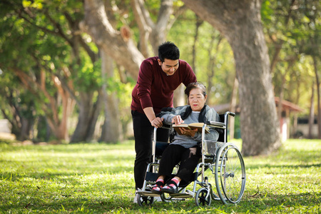 坐在轮椅上的亚洲老太太和儿子开心