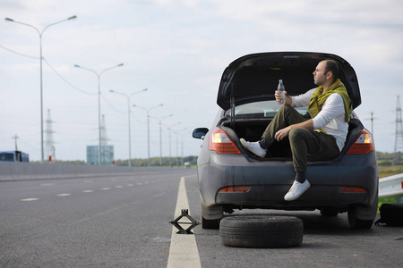 Replacing the wheel of a car on the road. A man doing tire work 