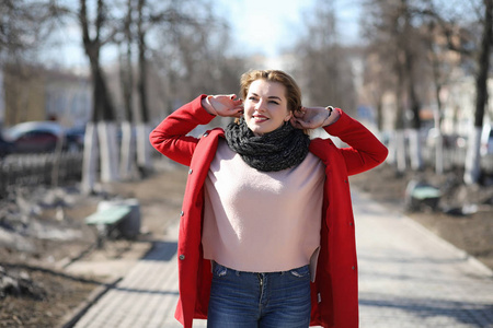 穿着红外套在城里散步的漂亮女孩