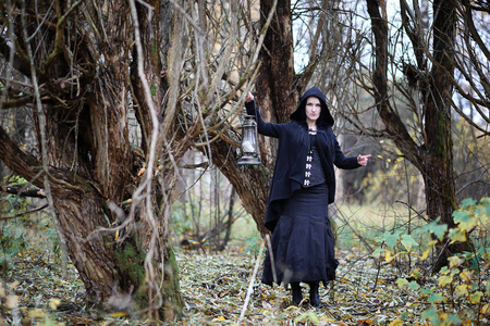 木材的女巫森林里穿着女巫服的女人照片