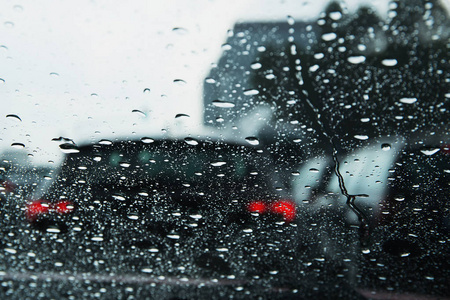 透过雨滴看到城市道路的挡风玻璃。