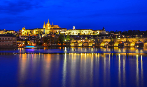 Prague skyline and bridge over river in night 