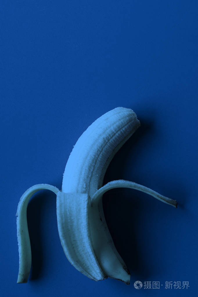 蓝色背景纸上的香蕉深蓝色调图像