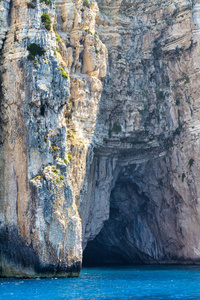 Steep cliffs with sea caves on the coast of the Paxos island. 