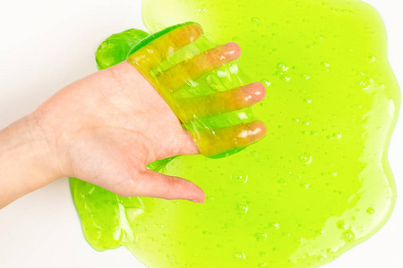 绿色粘液玩具在妇女手隔离白色。