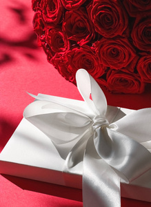 豪华假日丝绸礼品盒和红色背景玫瑰束