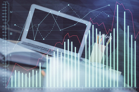 有电脑背景的图表财务信息和工作空间的双重曝光。国际网上交易的概念。