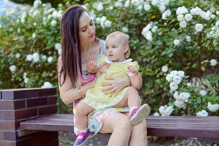 Happy mother and daughter in the park. Beauty nature scene with 