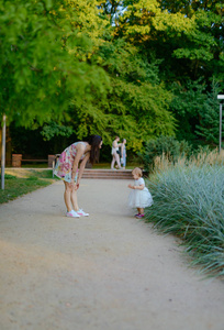 Happy mother and daughter in the park. Beauty nature scene with 