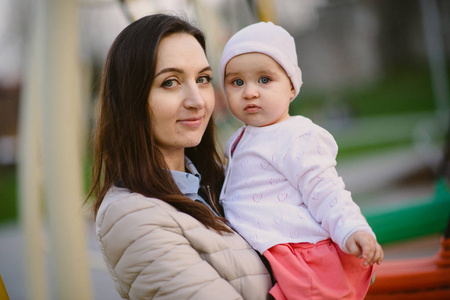 Happy mother and daughter in the park. Beauty nature scene with 