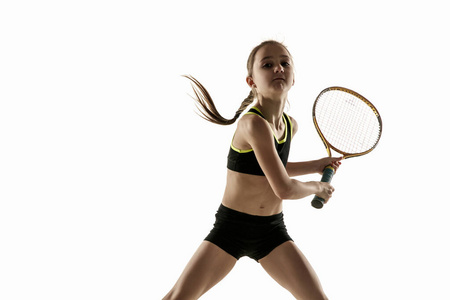 在白色背景下孤独地打网球的白人小女孩