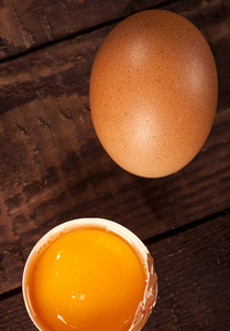 褐色的鸡蛋和带蛋黄的碎鸡蛋放在乡村餐桌上。