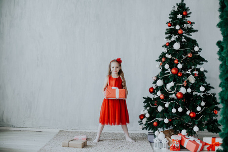 小女孩打开圣诞礼物新年树装饰